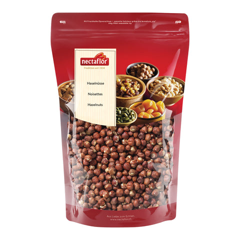 Roter Standbeutel mit transparentem Sichtfenster, gefüllt mit ganzen Haselnüssen. Auf dem Etikett steht „Haselnüsse / Noisettes / Hazelnuts“ unter dem Nectaflor Logo. Im oberen Bereich sind verschiedene Nüsse und Trockenfrüchte in Schalen abgebildet.