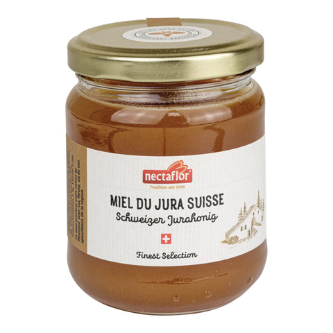 Glas mit goldfarbenem Deckel und Etikett mit der Aufschrift 'nectaflor MIEL DU JURA SUISSE Schweizer Jurahonig Finest Selection' und einer kleinen Zeichnung eines Hauses