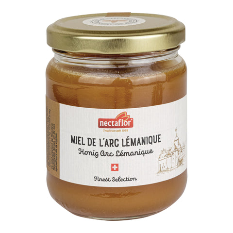 Glas mit goldfarbenem Deckel und Etikett mit der Aufschrift 'nectaflor Tradition seit 1958 MIEL DE L'ARC LÉMANIQUE Honig Arc Lémanique Finest Selection' und einer Zeichnung eines Schlosses