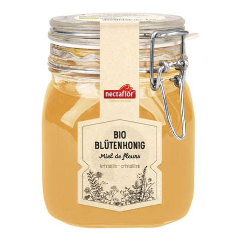 Glas mit hellgelbem Bio-Blütenhonig der Marke nectaflor mit Metallbügelverschluss und Etikett mit floralen Zeichnungen