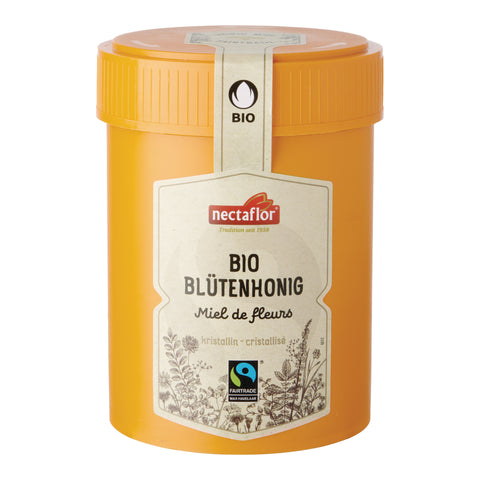Gelber Honigbehälter mit Aufkleber 'nectaflor BIO BLÜTENHONIG Miel de fleurs kristallin - cristallisé' und Fairtrade-Siegel