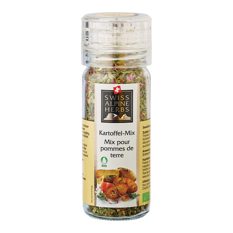 Transparente Gewürzmühle mit durchsichtigem Deckel. Auf dem Etikett steht „Kartoffel-Mix / Mix pour pommes de terre“ unter dem Swiss Alpine Herbs Logo. Im Glas sind grobe Kräuter und Gewürze sichtbar. Unten sind gebratene Kartoffeln, eine Tomate sowie das Bio-Logo abgebildet.