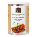 Weisse Gewürzdose mit goldenen Seitenstreifen. In der Mitte steht „Alpenkräuter-Chili ohne Salz / Chili aux herbes des Alpes sans sel“ unter dem Swiss Alpine Herbs Logo. Unten sind ein Gericht mit Bohnen und Mais, eine rote Chilischote und das Bio-Suisse-Logo abgebildet.