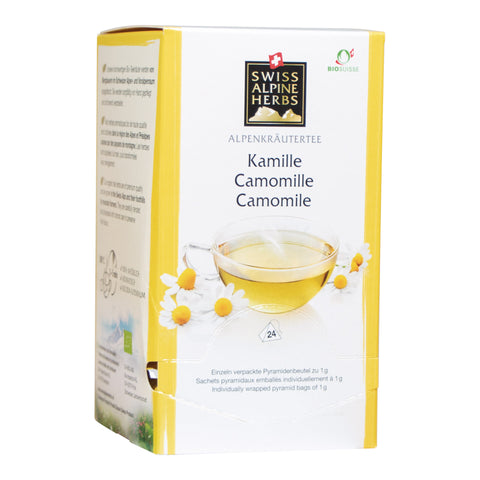 Packung Alpenkräutertee Kamille von Swiss Alpine Herbs mit Teetasse und Kamillenblüten