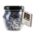 Glas mit violettem Blütensalz und Etikett „Swiss Alpine Herbs“.