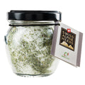 Glas mit grünem Kräutersalz und Etikett „Swiss Alpine Herbs“.