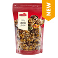 Rote Verpackung mit durchsichtiger Front, gefüllt mit bunter Früchtebrotmischung, Aufkleber mit Logo 'nectaflor' und Text in drei Sprachen