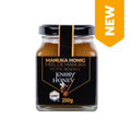 Glas mit Manuka-Honig der Marke Knopf Honey mit schwarzem Etikett und goldener Schrift, 250 Gramm