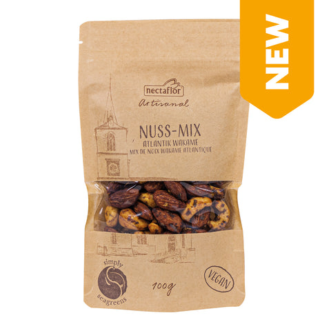 Braune Verpackung mit transparentem Sichtfenster, das eine Mischung aus Nüssen zeigt, mit Aufdruck 'nectaflor Artisanal NUSS-MIX ATLANTIK WAKAME' und veganem Siegel